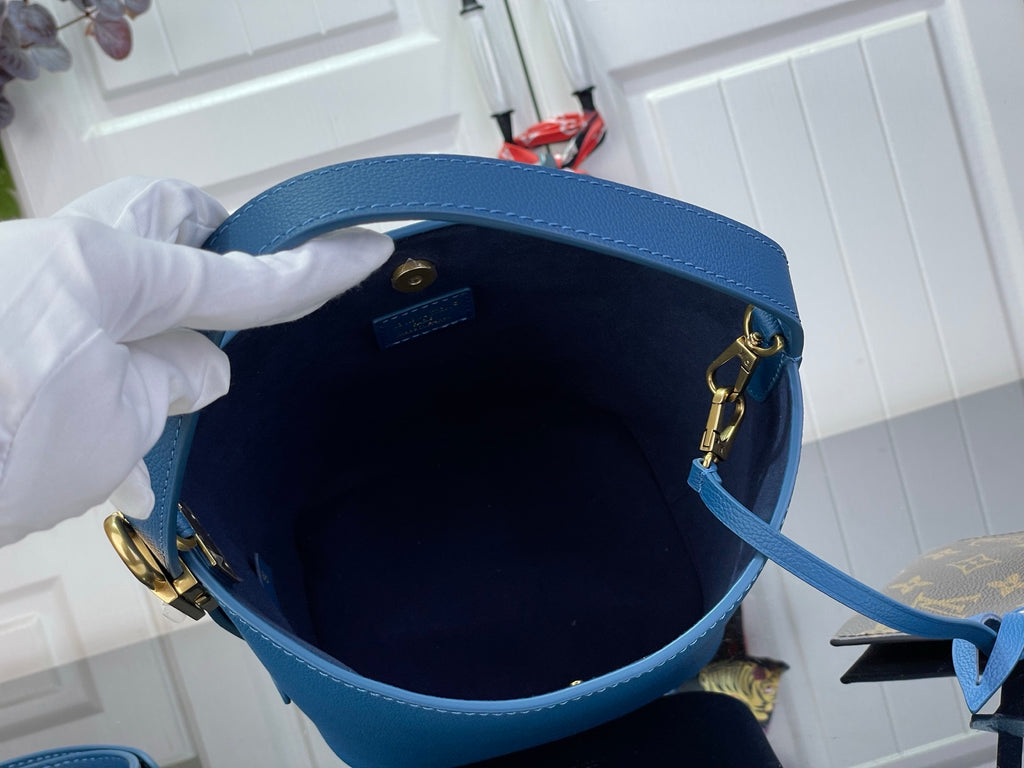 Blue leather bag interior with gold-tone zipper and shoulder strap loop
