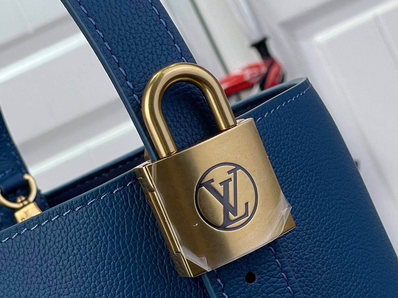 Blue leather bag with gold-tone padlock and chain hardware