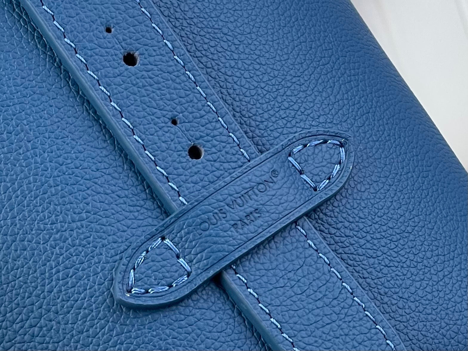 Blue leather strap with stitched edges and metal ring keeper