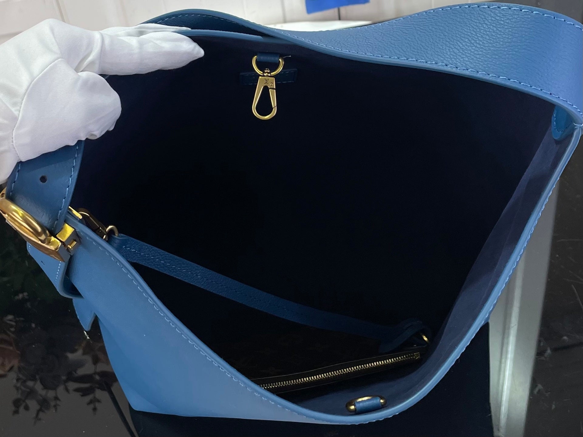 Louis Vuitton blue tote interior with top zipper and hanging gold key ring clasp