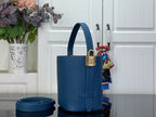 Blue bucket bag with top handle and front strap buckle detail