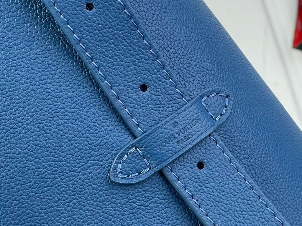 Louis Vuitton blue leather strap detail with stitched closure and embossed logo