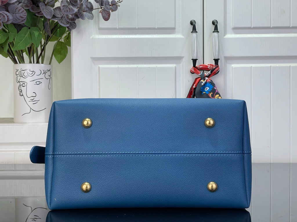 Louis Vuitton blue structured tote bag front with gold studs and stitched trim