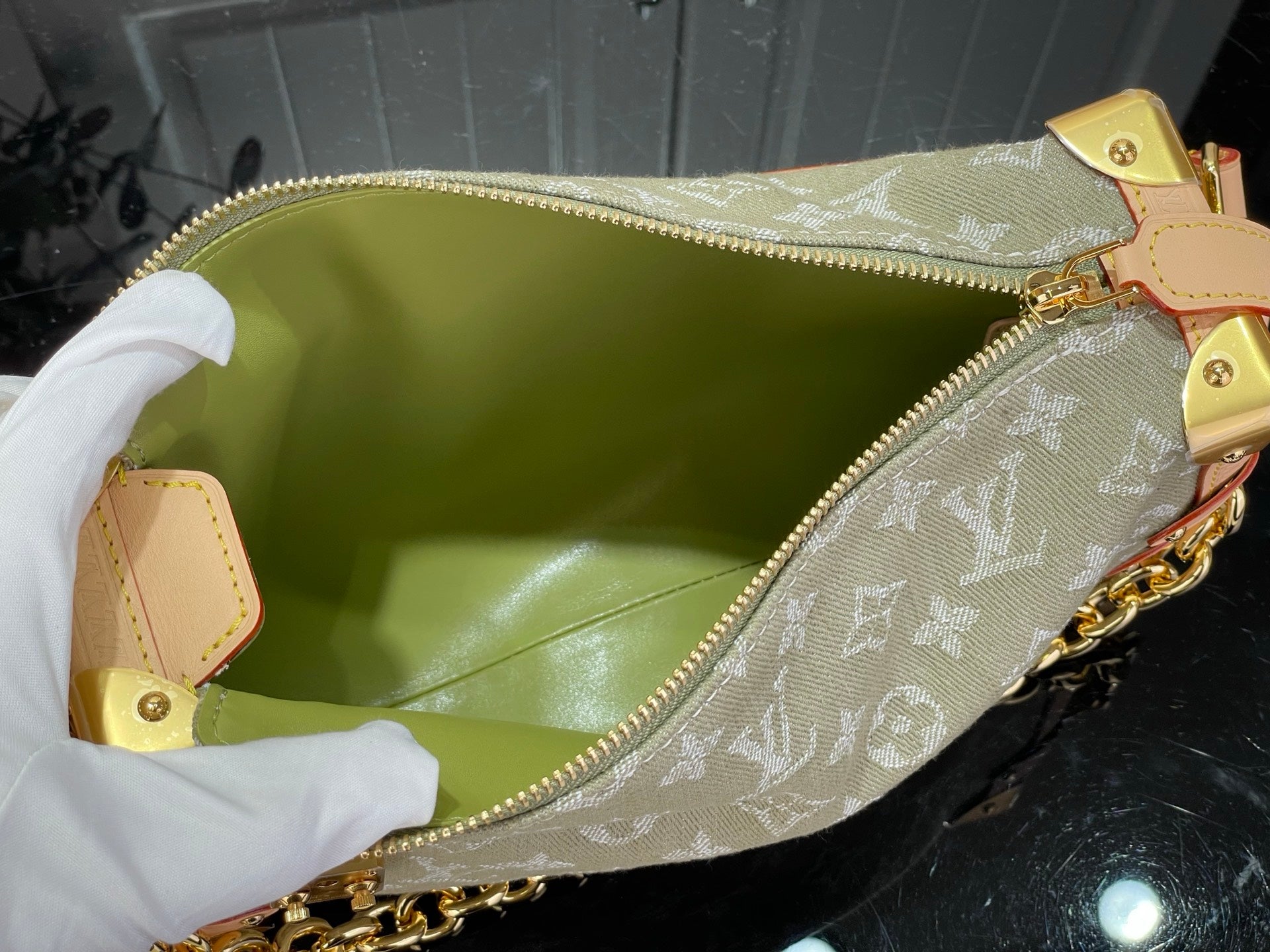 Louis Vuitton monogram bag with gold zipper, chain handle, and olive green lining