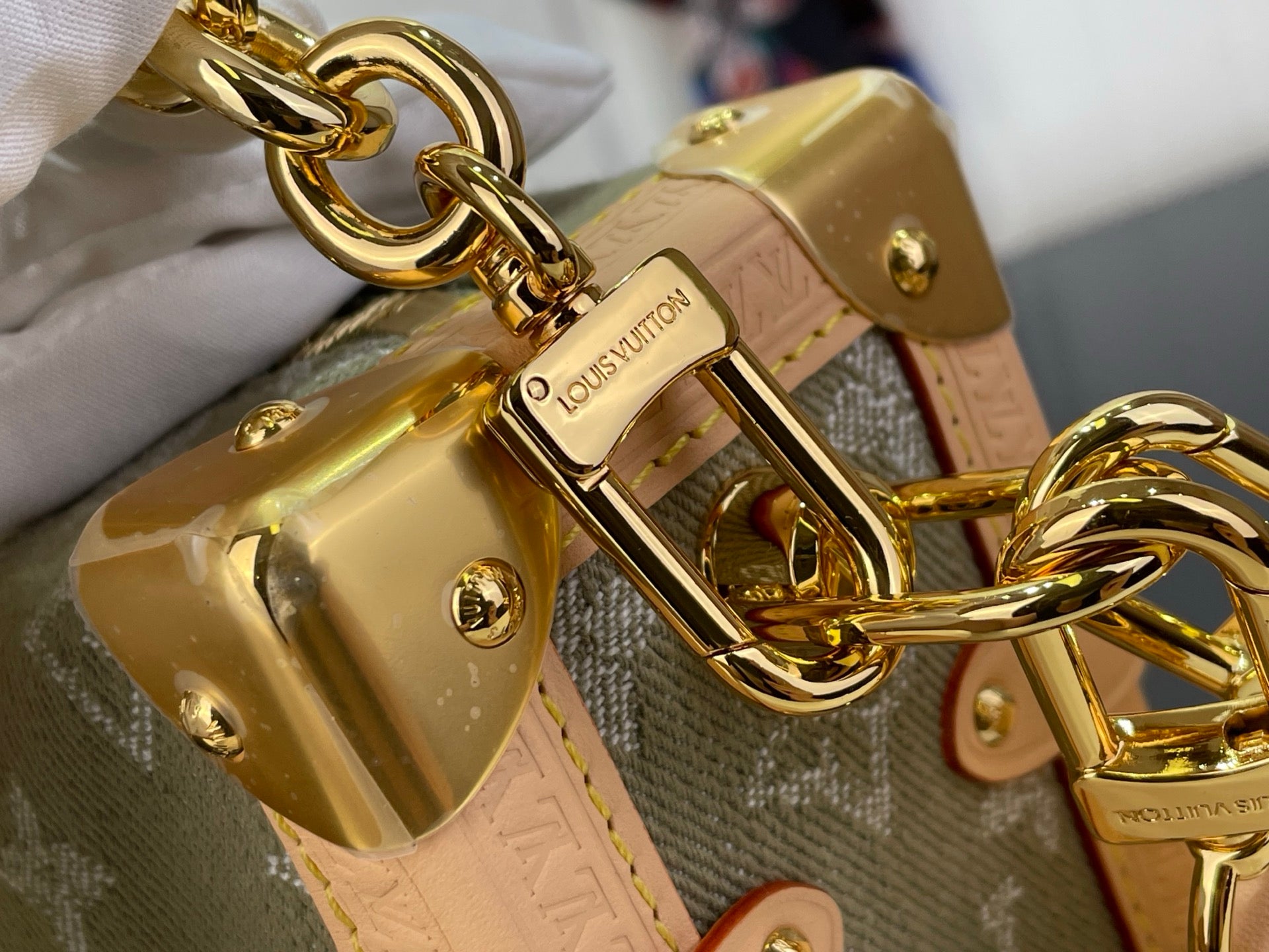 Louis Vuitton gold-tone lock plate with chain links on monogram bag strap