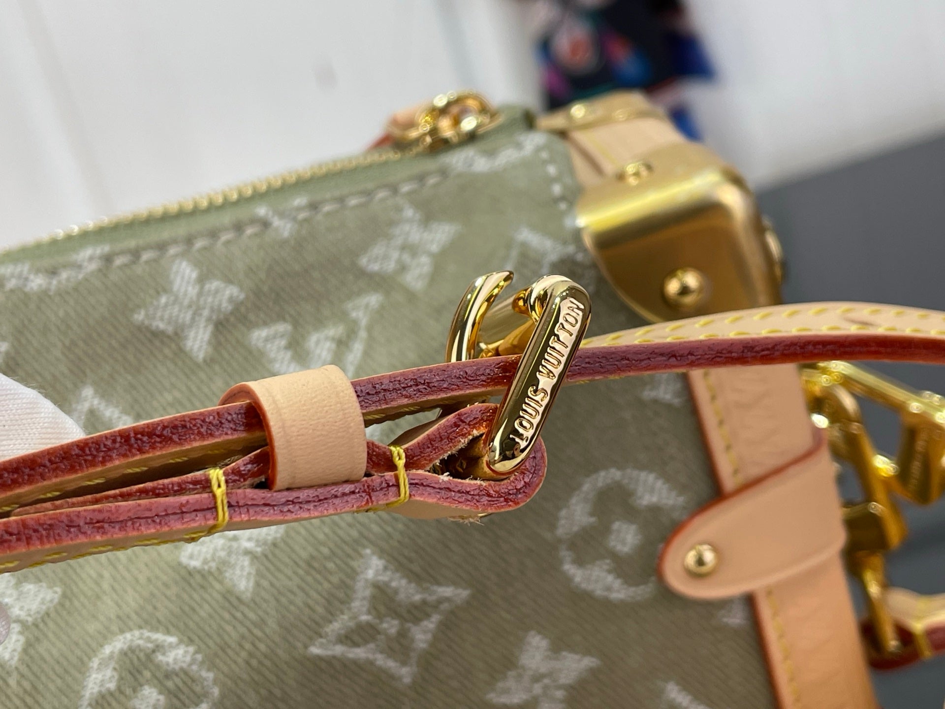 Louis Vuitton monogram bag zipper pull with red-brown leather strap and gold charm