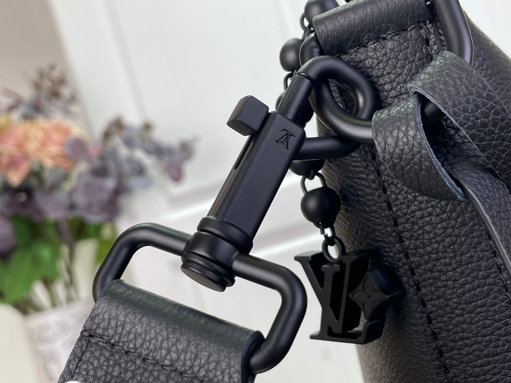 Louis Vuitton hobo bag close-up of strap hardware and hanging charm