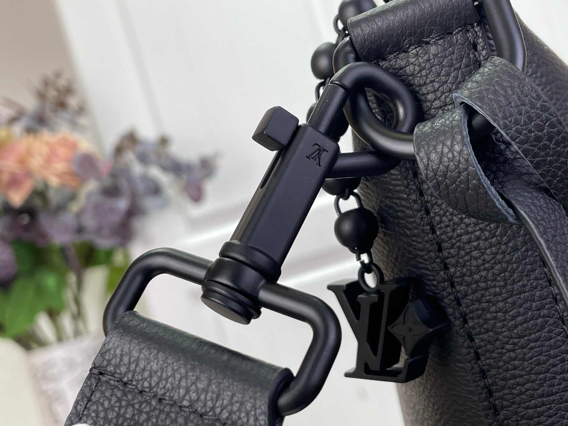 Louis Vuitton hobo bag close-up of strap hardware and hanging charm