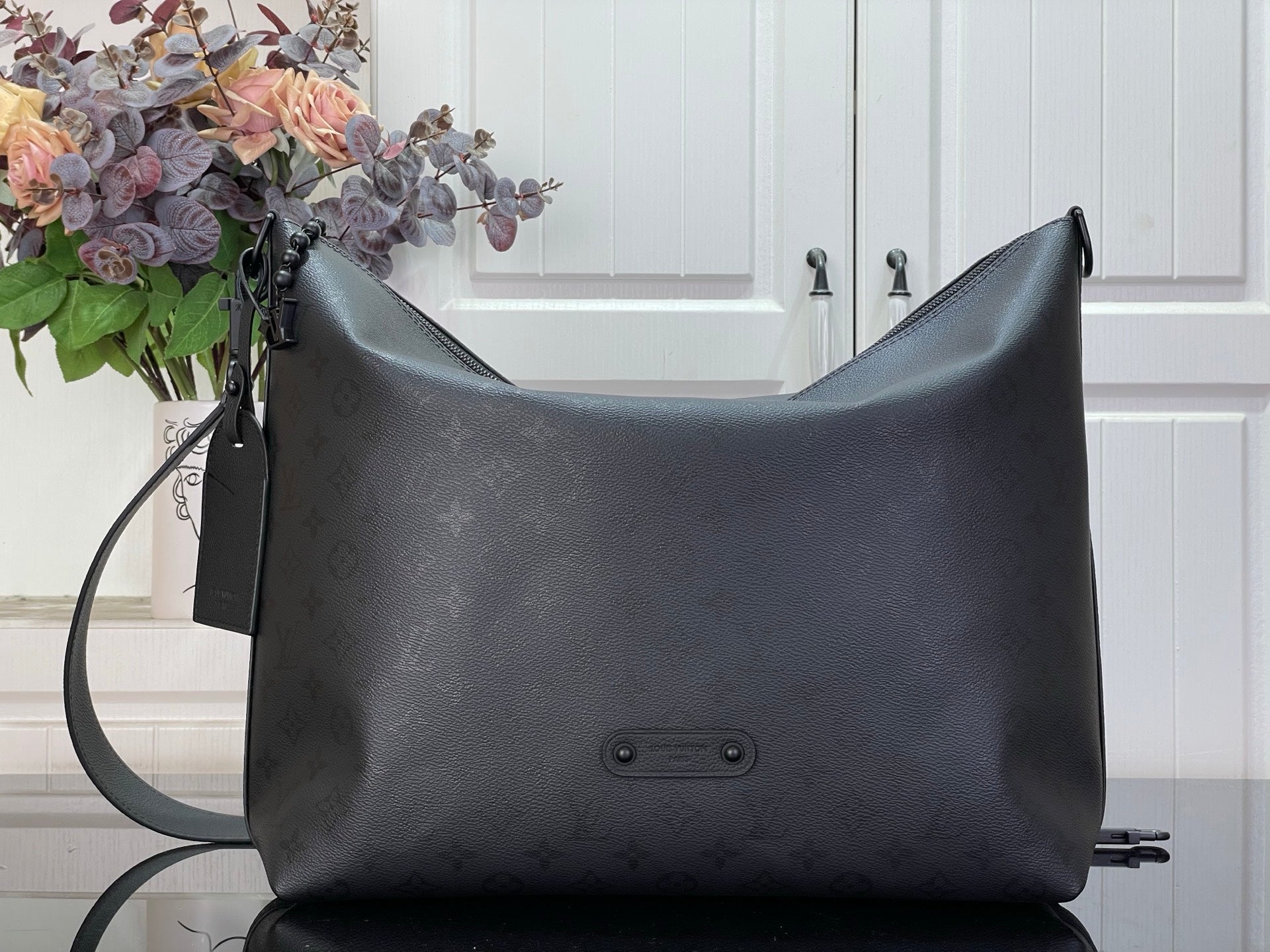 Louis Vuitton hobo bag in dark textured leather with top zip and front snap pocket