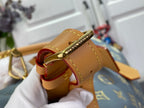 Louis Vuitton bag strap detail with gold buckle hardware and tan leather trim