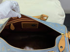 Louis Vuitton bag open top with blue exterior, gold monogram pattern, and brown interior
