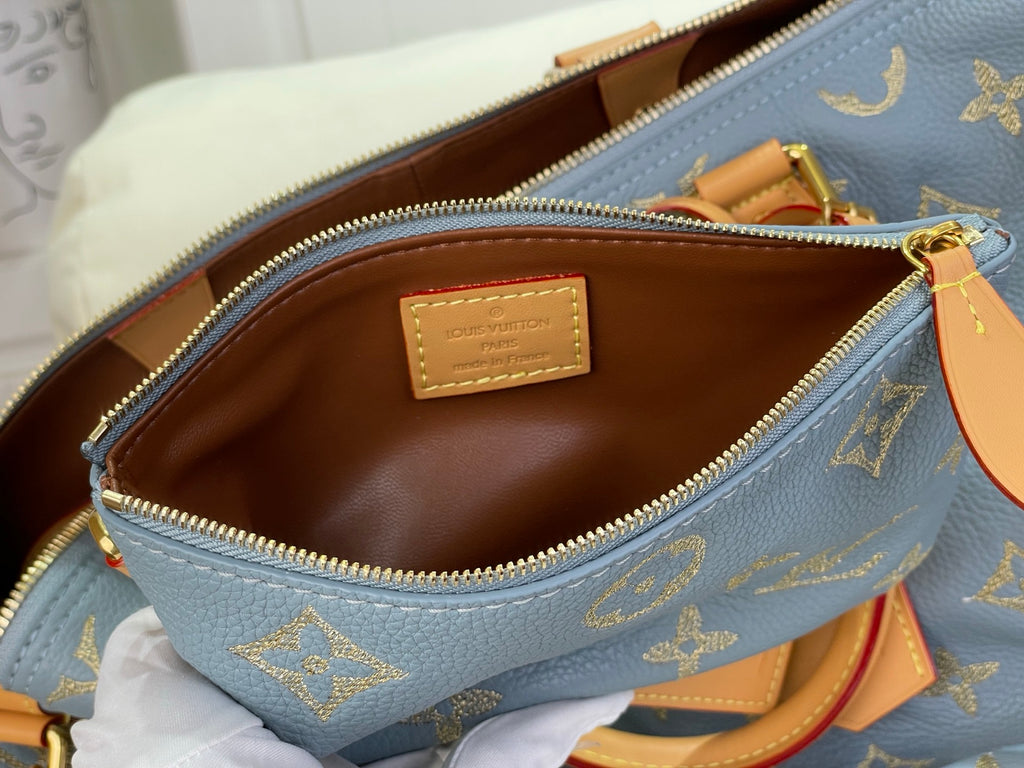 Louis Vuitton bag interior view with brown lining and tan logo patch near zip opening