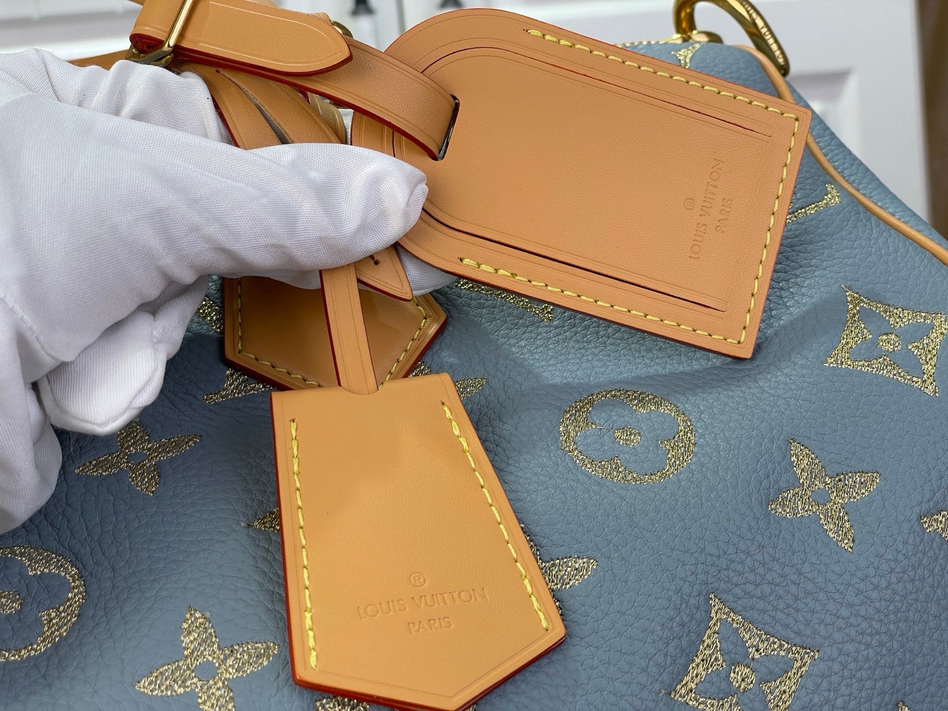 Louis Vuitton light blue monogram tote bag with tan leather tag charms and gold stitching