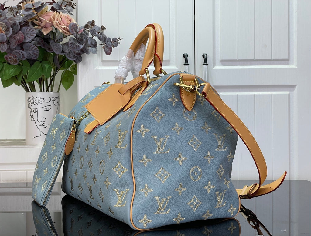 Louis Vuitton light blue monogram tote bag with tan strap and gold hardware in side view