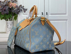 Louis Vuitton light blue monogram tote bag with tan strap and gold hardware in side view