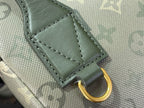 Gray-green leather patch with gold D-ring on Louis Vuitton monogram bag