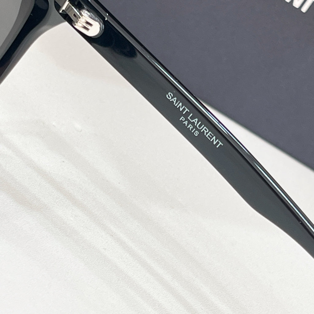 YSL black sunglasses arm close-up with engraved logo text