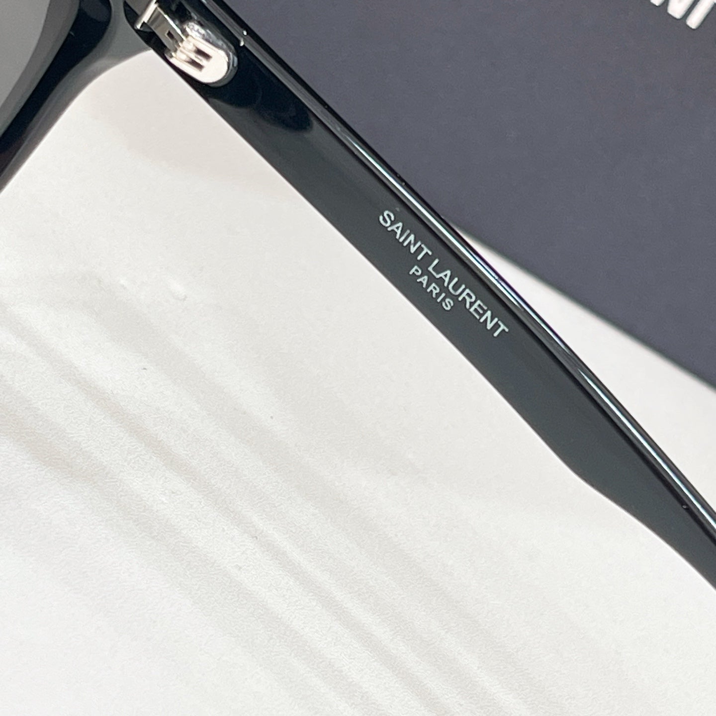 YSL black sunglasses arm close-up with engraved logo text