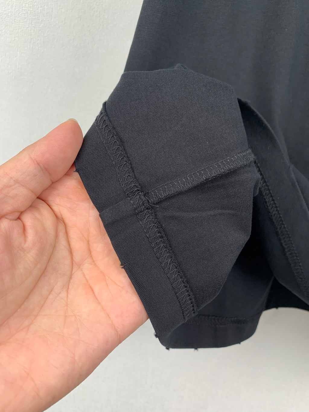 Navy short-sleeve T-shirt cuff and side seam stitching detail