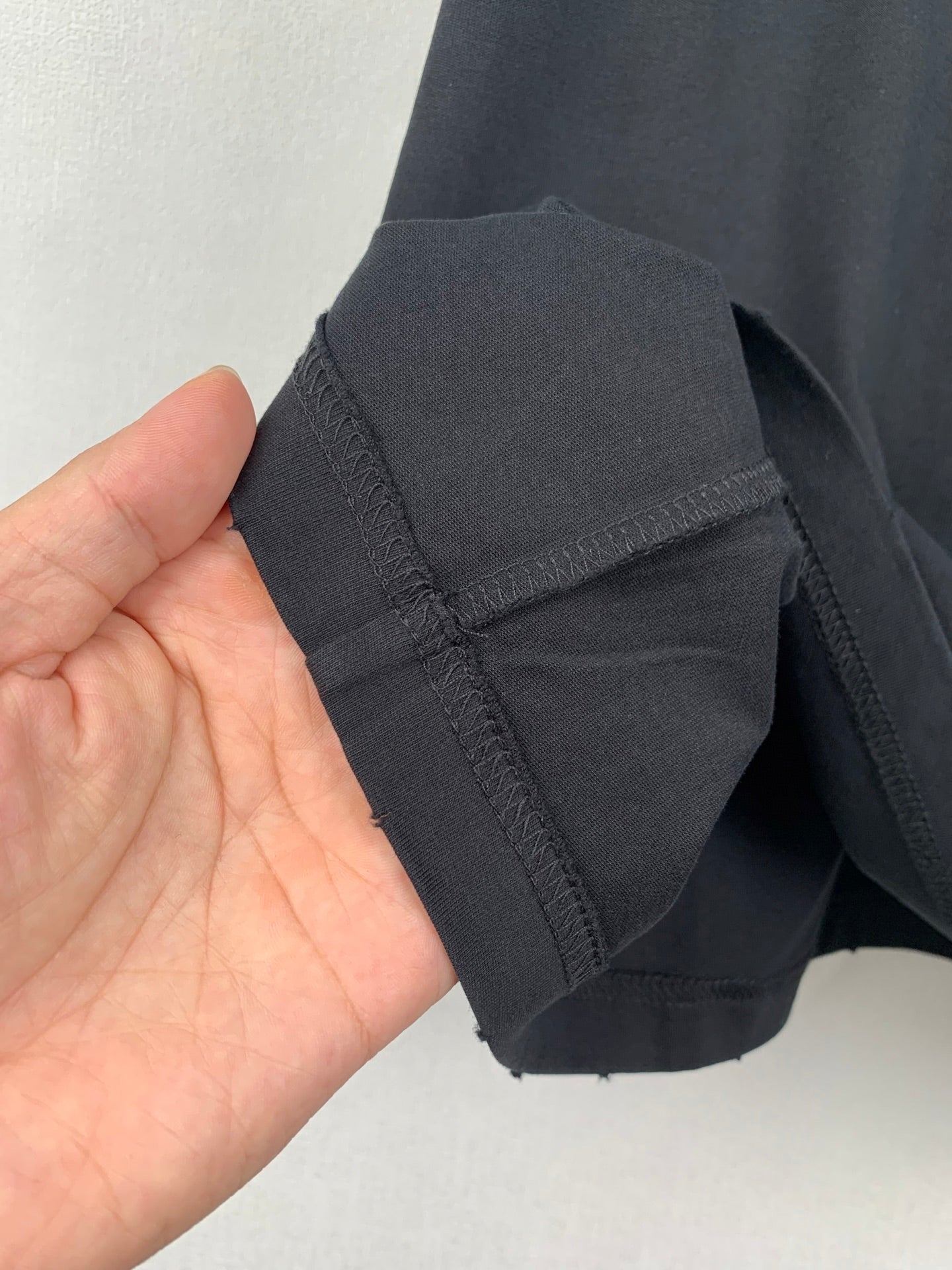 Navy short-sleeve T-shirt cuff and side seam stitching detail