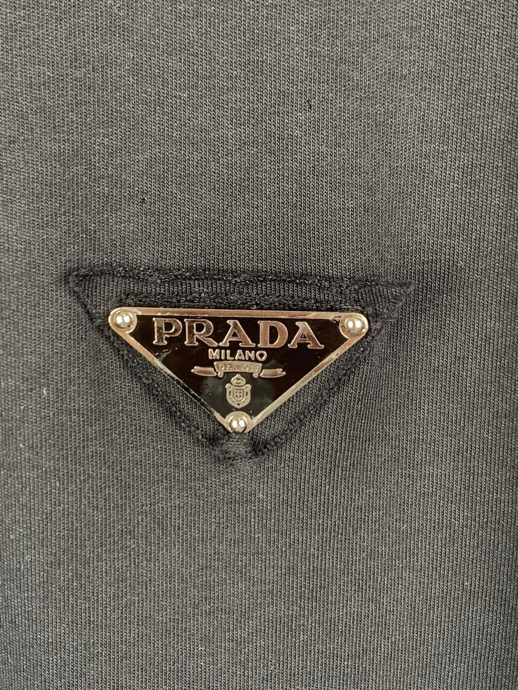 Prada triangle logo patch on dark T-shirt fabric
