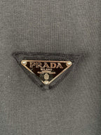 Prada triangle logo patch on dark T-shirt fabric