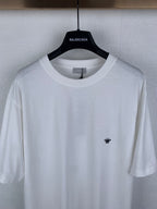 Dior short-sleeve T-shirt, close-up of white crew neck and small black chest emblem