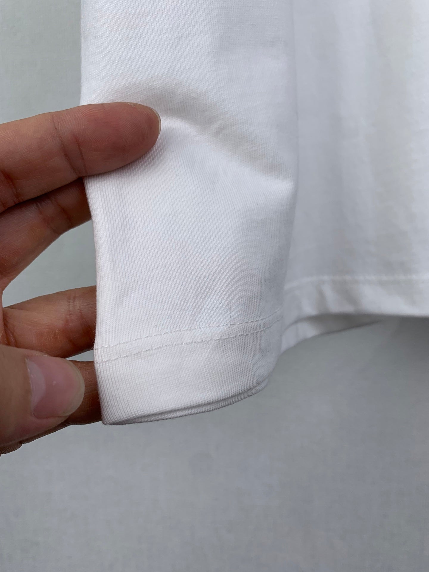 Dior short-sleeve T-shirt, cuff/hem seam close-up in white