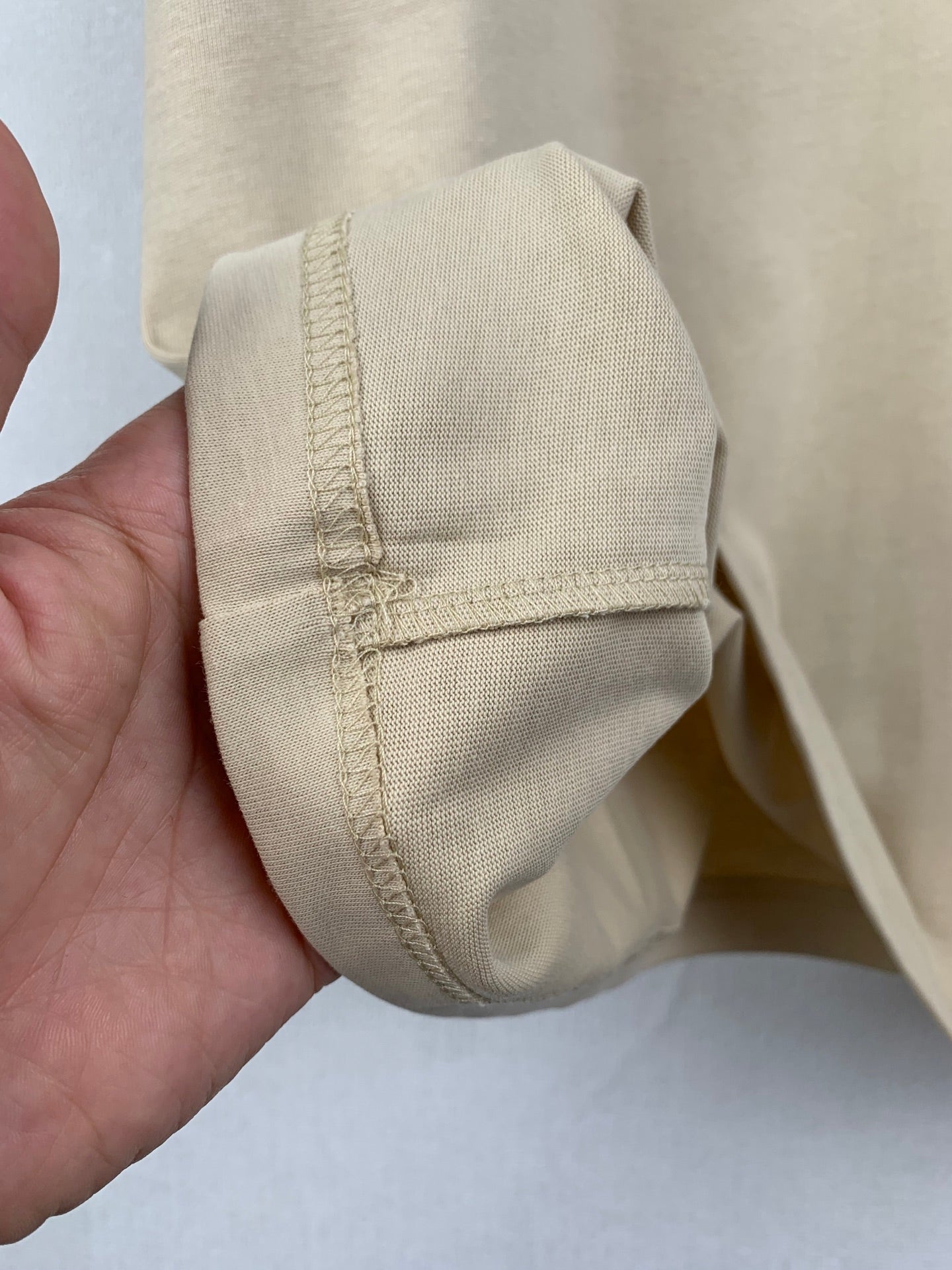 Beige T-shirt cuff with folded hem stitching