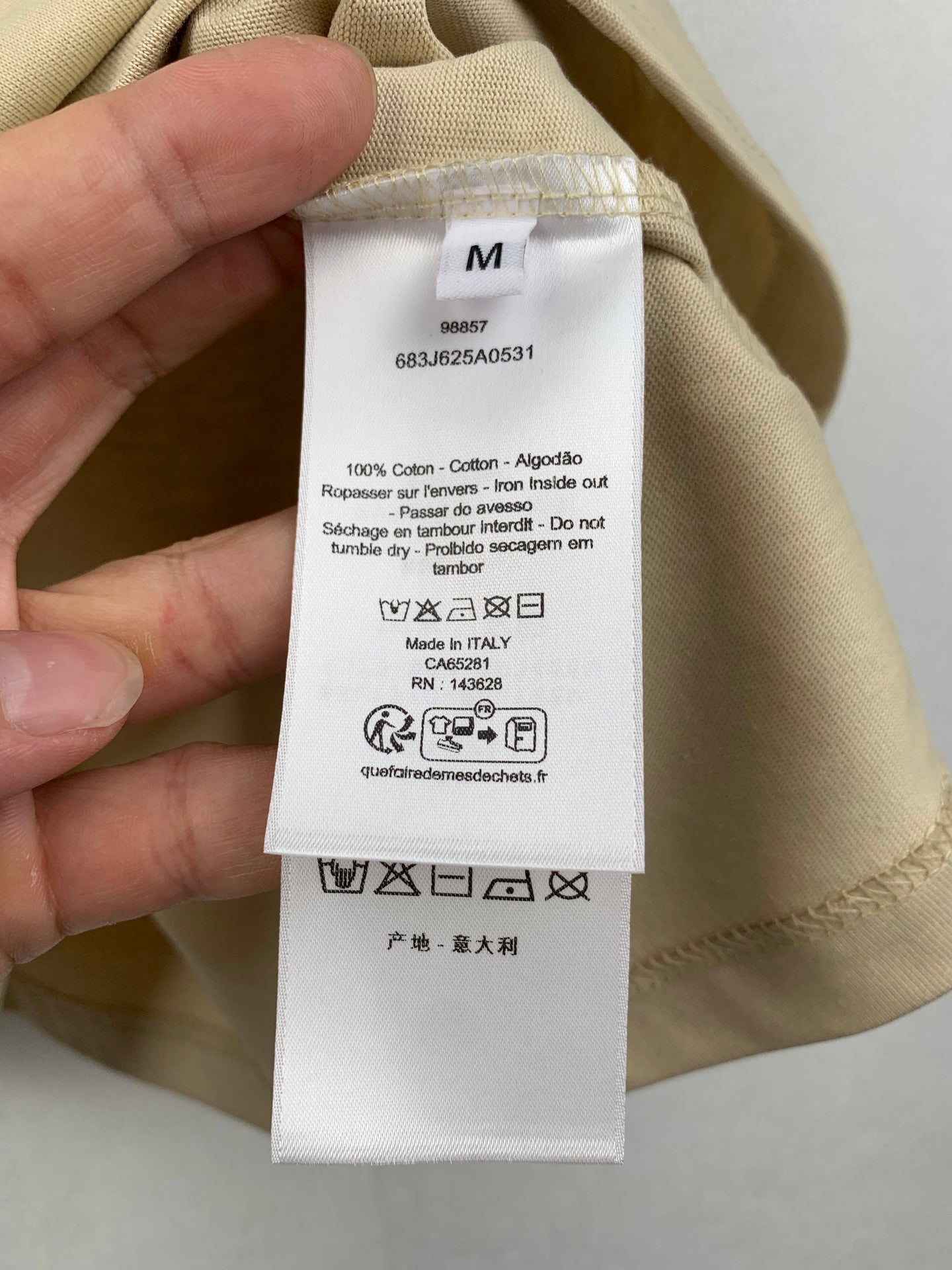 Beige T-shirt care and size label inside collar