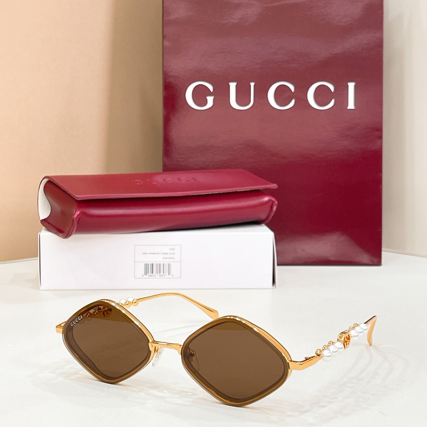 Gold round sunglasses with brown-tinted lenses and pearl beaded temple accents