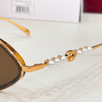 Gold sunglasses temple with pearl bead detailing and decorative emblem