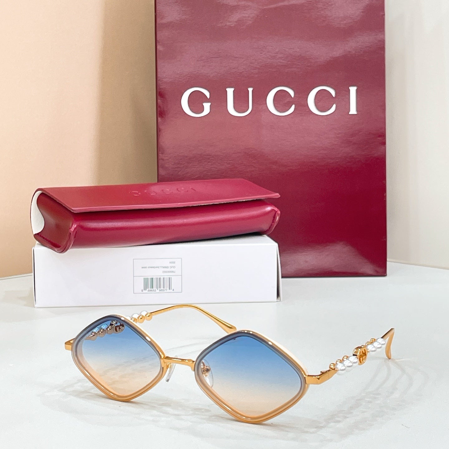 Gold round sunglasses with light blue lenses and pearl beaded temple accents
