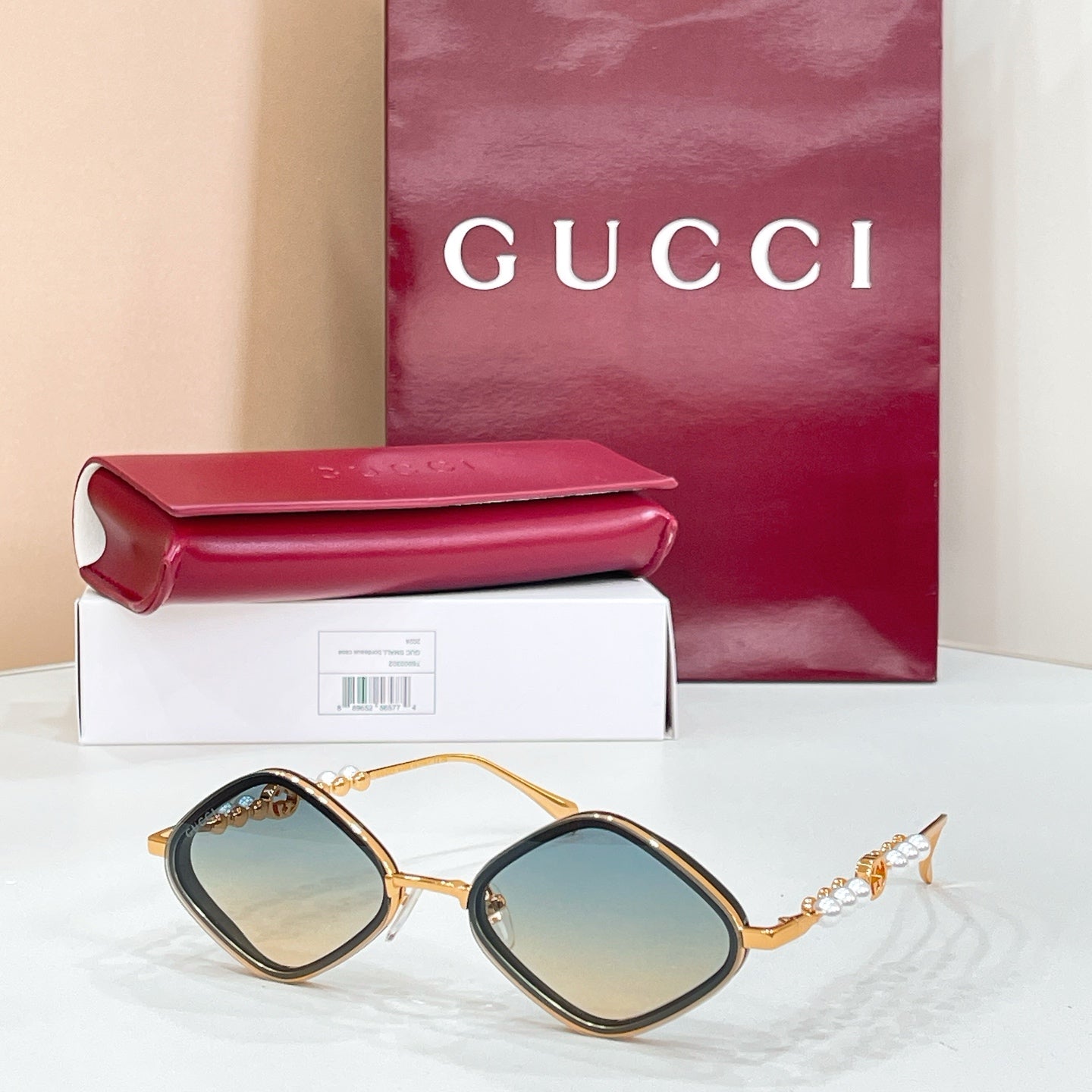 Gold round sunglasses with blue-tinted lenses and pearl beaded temple accents