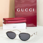 Gucci sunglasses with gold frame, dark lenses, oval shape and pearl-like accents on temples