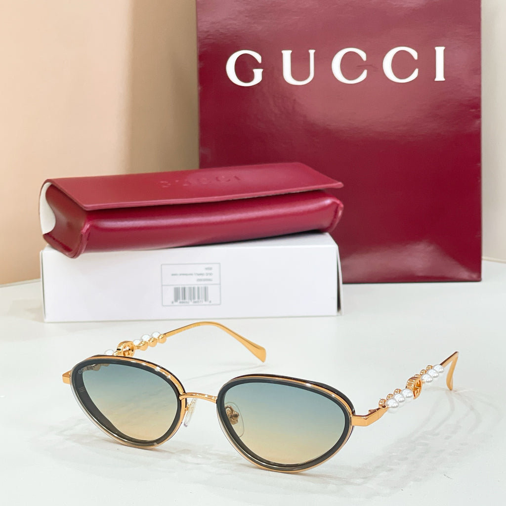 Gucci sunglasses with gold frame, light lenses and subtle tint, oval shape, pearl accents