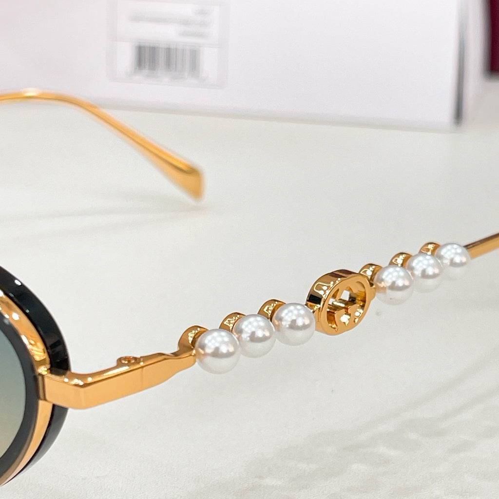 Gucci sunglasses detail: gold frame with pearl beading on temple and decorative hinge