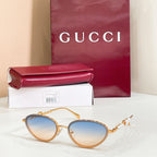 Gucci sunglasses with gold frame, light blue tint lenses, oval shape and pearl accents