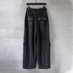 Dark cargo pants on hanger with elastic waistband, flap pockets, and hanging zipper pull tabs