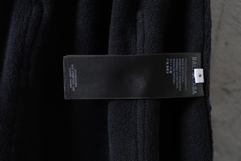 Dark fabric cargo pants with attached brand label tag on the waistband area