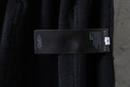 Dark fabric cargo pants with attached brand label tag on the waistband area