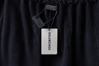 Dark cargo pants with branded hang tag on the waistband, elastic top edge