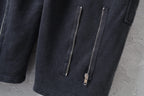Dark cargo pants with two vertical zip pockets on the leg and metal zipper pulls