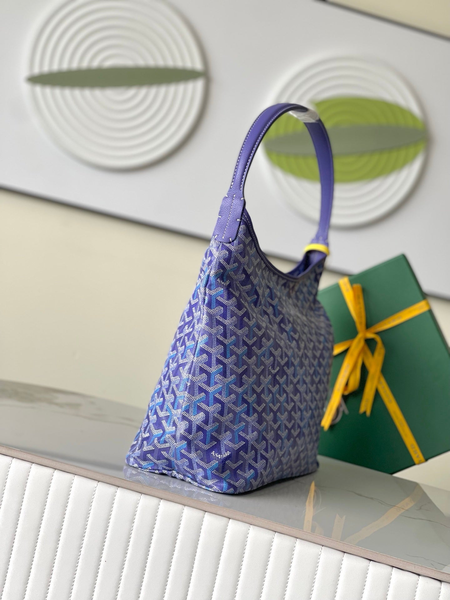 Purple patterned tote-style bag with short handle and yellow bow ribbon detail