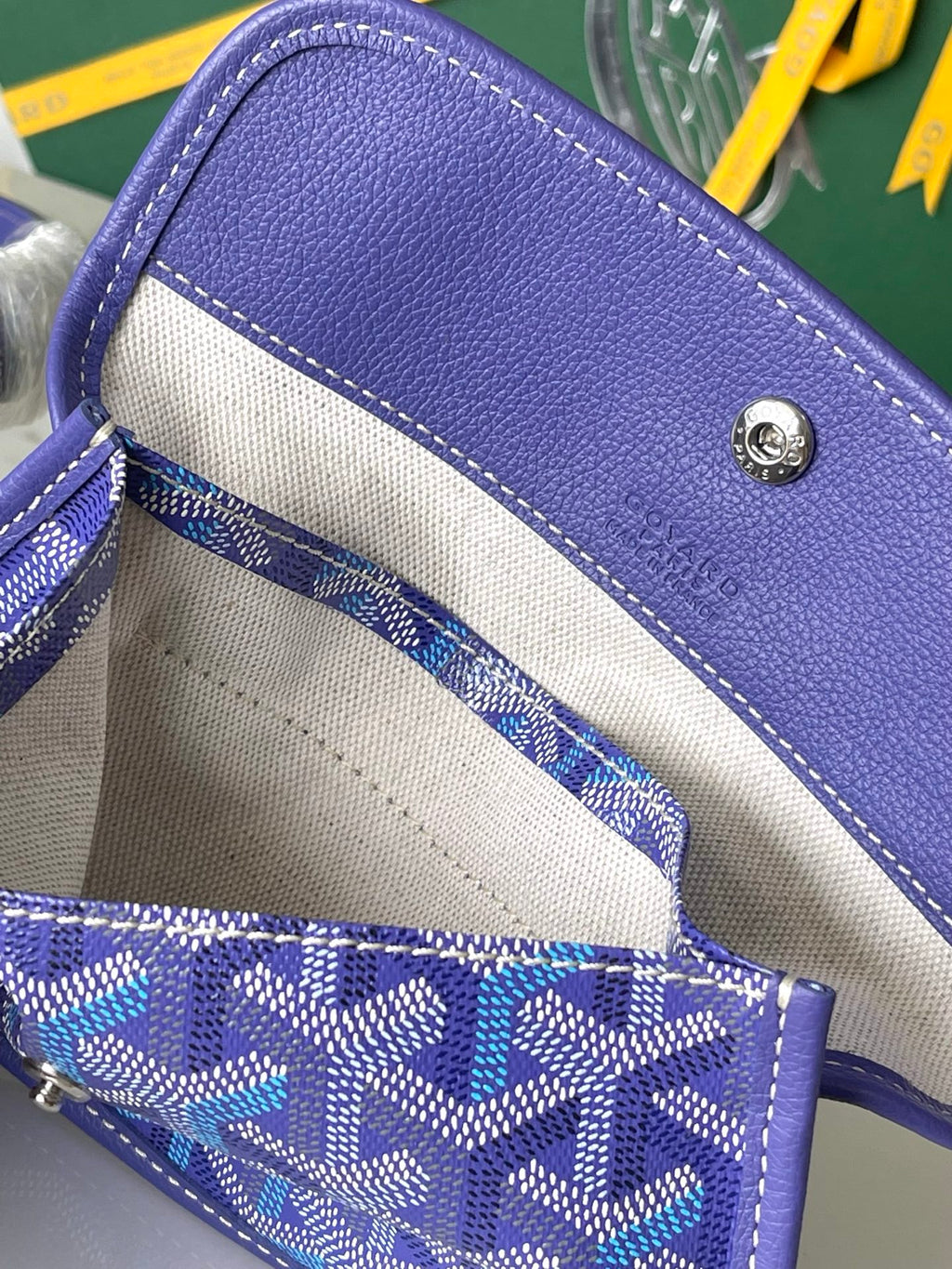 Open purple patterned bag with light interior lining and stitched edge trim