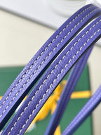 Blue leather-trim tote handle close-up with stitched edges and textured grain