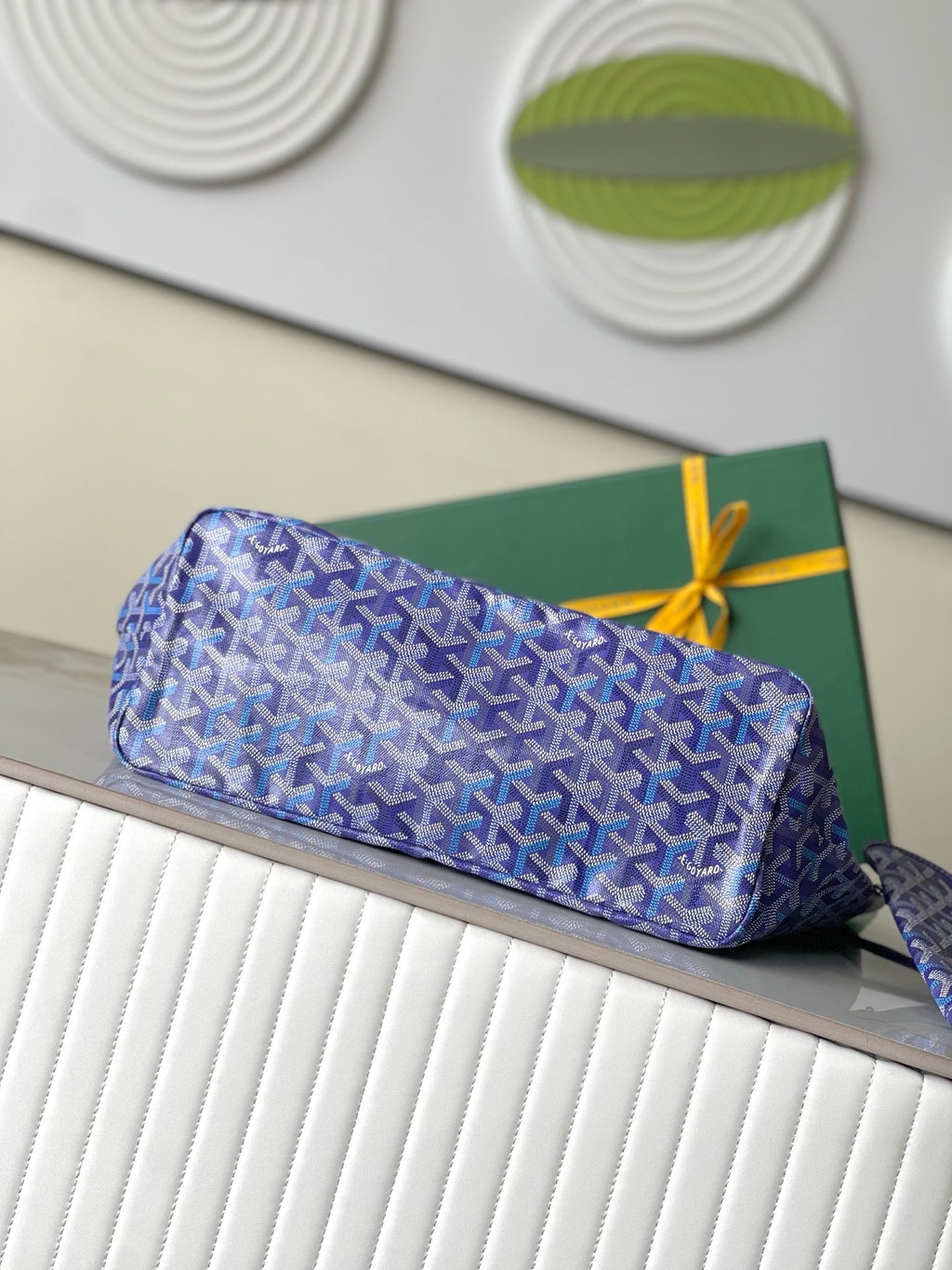 Blue patterned zip pouch with leather trim and bow tie closure