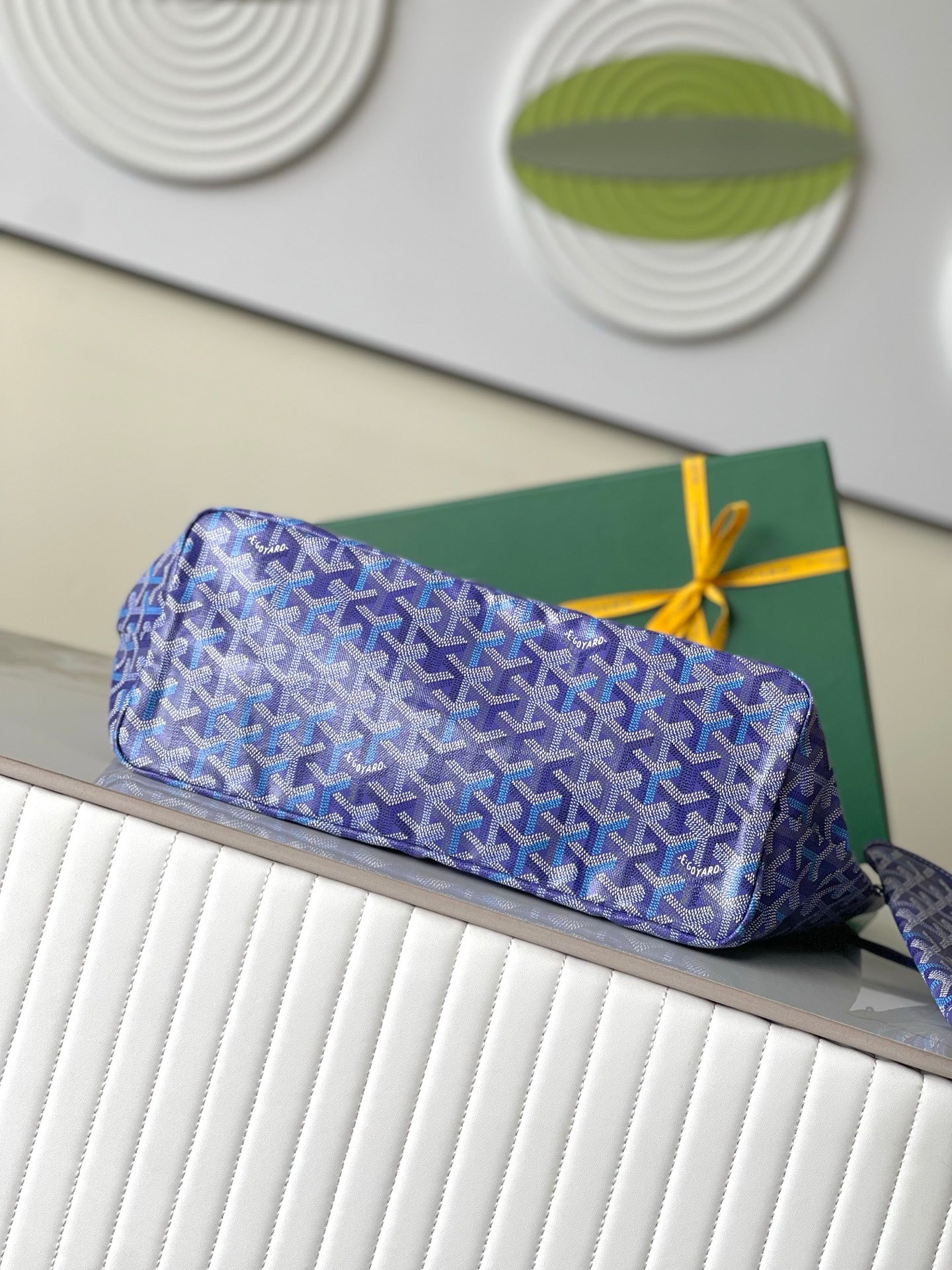 Blue patterned zip pouch with leather trim and bow tie closure