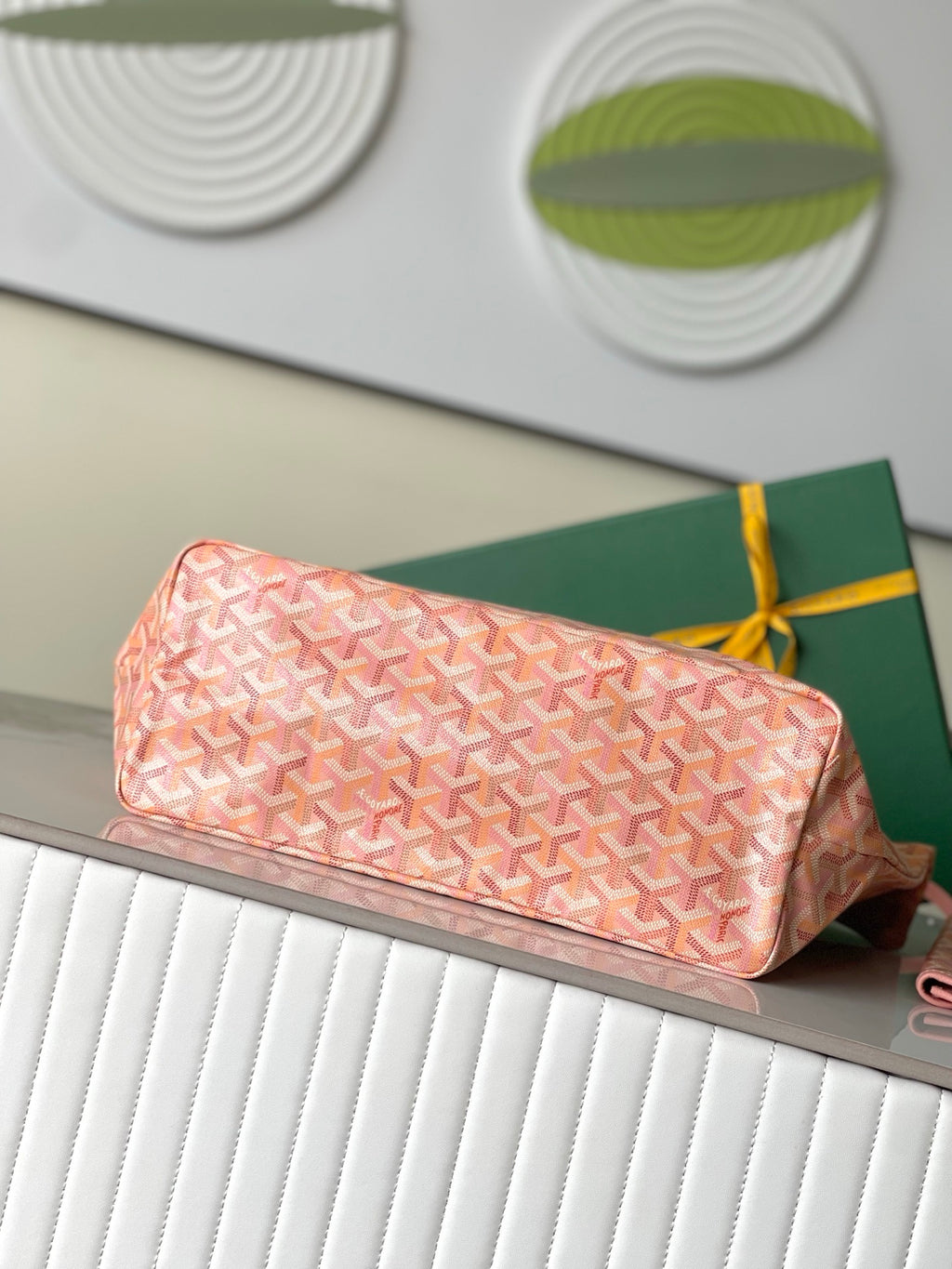 Pink Goyard patterned clutch pouch with zipper, shown on top of tote