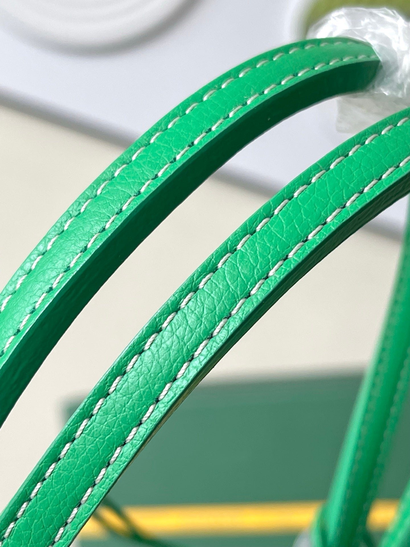 Green leather-look tote handles with visible stitching and rings